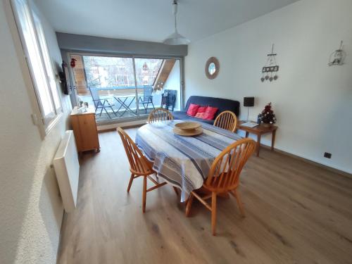 un salon avec une table, des chaises et un canapé dans l'établissement T2 spacieux et lumineux avec 2 terrasses Sud et Est, proche centre village, à Saint-Lary-Soulan