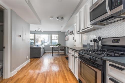 a kitchen with a stove and a living room at The Bright Retreat in Andersonville in Chicago