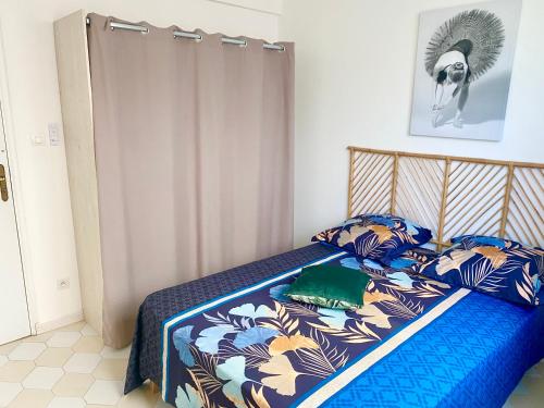 a bedroom with a bed with a blue comforter at Cocoline in Vieux-Fort
