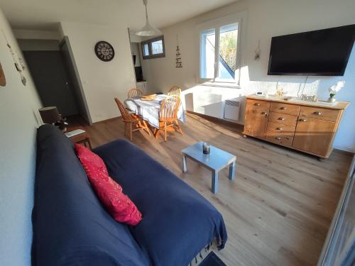 un salon avec un canapé bleu et une table dans l'établissement T2 spacieux et lumineux avec 2 terrasses Sud et Est, proche centre village, à Saint-Lary-Soulan