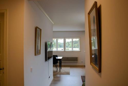 a hallway with a room with a table and a window at Modern Country Apartment in Borlänge