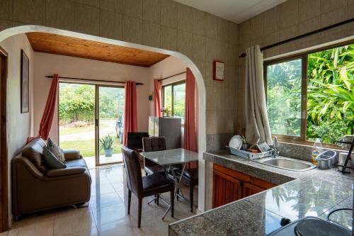 a kitchen with a sink and a table and chairs at Tropical Beach House in Grand Anse