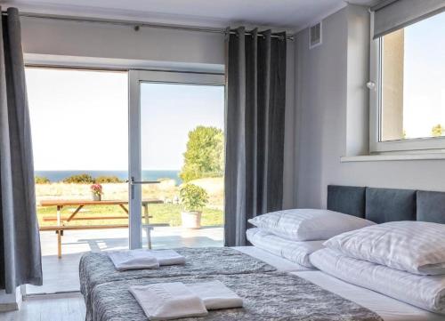 a bedroom with two beds and a large window at Bornholm Apartments in Svaneke