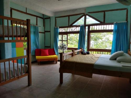 a bedroom with a bed and a large window at Cielo Hostel in Taganga