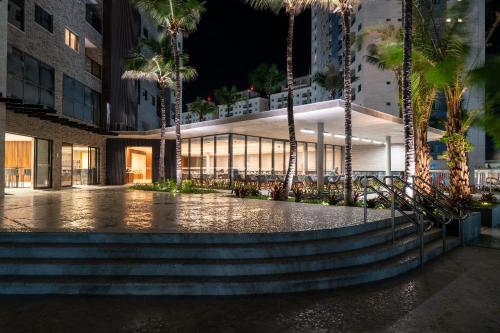 a building with palm trees in front of it at Salinas Premium Resort in Salinópolis