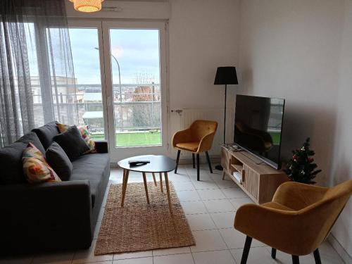 a living room with a couch and a tv and a christmas tree at Superbe appartement ,6 pers, proche de Paris, dans résidence privée , parking et WIFI gratuits! ! in Vitry-sur-Seine