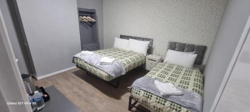 two beds in a small room with two at Elstree Inn in Borehamwood