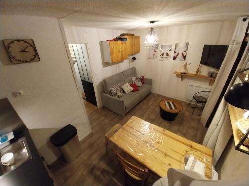 an overhead view of a living room with a couch and a clock at VALLOIRE, studio 22m2, tout à pied, remontées mécaniques à 100m in Valloire