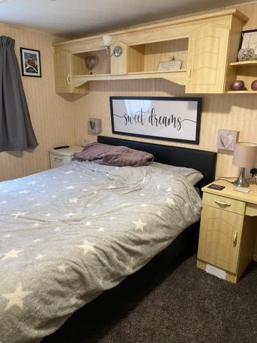 Un dormitorio con una cama grande con un cartel encima. en Bobbys Bolthole2, en Heysham