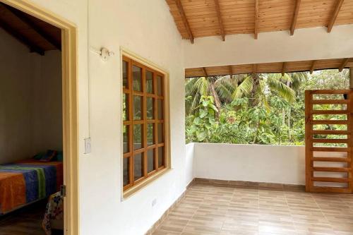 a room with a window and a bedroom with a bed at Palm House Getaway-150 m to sea in Necoclí