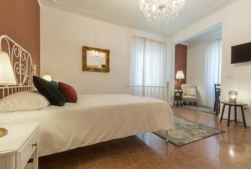 a bedroom with a white bed and a chandelier at Casa dei Liuti in Alghero