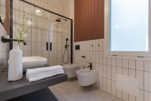 bagno bianco con lavandino e servizi igienici di Casa dei Liuti ad Alghero