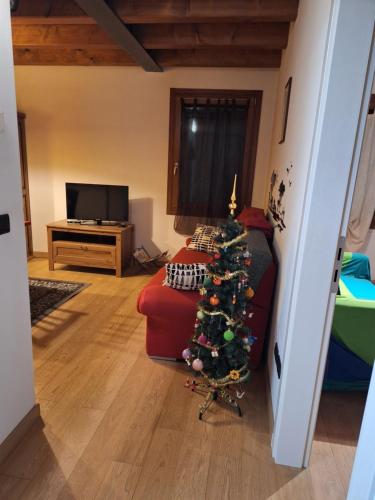 een kerstboom in een woonkamer met een rode bank bij Vista Rocca Alberi, 100 passi in Montagnana