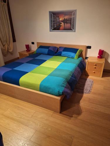 een slaapkamer met een bed met blauwe en groene lakens bij Vista Rocca Alberi, 100 passi in Montagnana