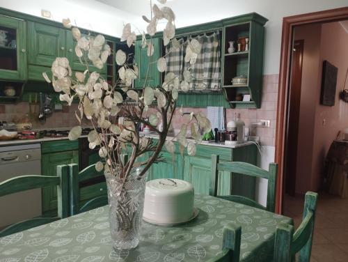 a vase of flowers on a table in a kitchen at Ferula loft in Sortino