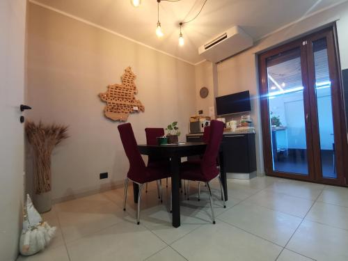a dining room with a table and red chairs at The Piedmont Gate, Walk to Metro, 2 Bedroom Apartment, Terrace, Baby Equipment, AC, Near Shopping Center in Collegno