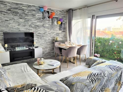 un soggiorno con un divano e un tavolo di Magnifique appartement 10 min de Paris - Parking privée Gratuit a Chevilly-Larue