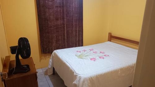 a bedroom with a bed with pink flowers on it at Capão da Canoa felicidade in Capão da Canoa