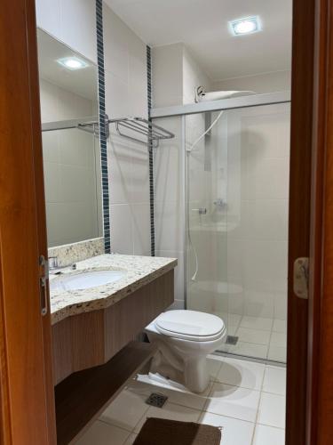 a bathroom with a toilet and a sink and a shower at Veredas do Rio Quente 116 in Rio Quente