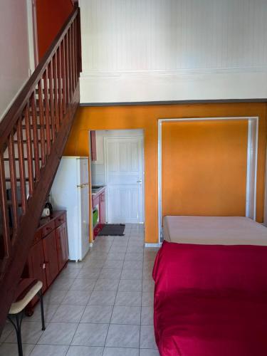 ein Schlafzimmer mit einem Bett und einem Treppenaufgang in der Unterkunft Gîte Allée des Cocotiers in Saint-François