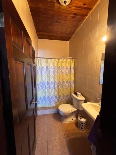 een badkamer met een toilet, een wastafel en een bad bij Sunset Views Apartment, West End in West End