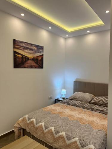 a bedroom with a bed with a painting on the wall at Surčin Centar apartment in Surčin