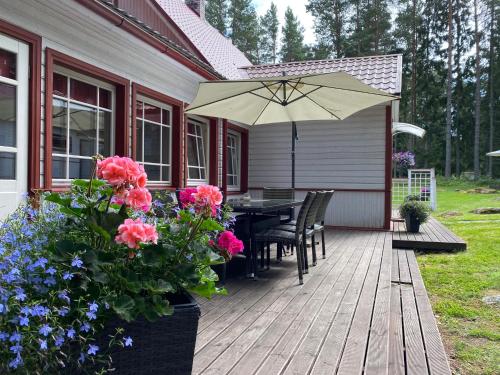 a wooden deck with a table and an umbrella at Sinisalu Apartments in Käsmu
