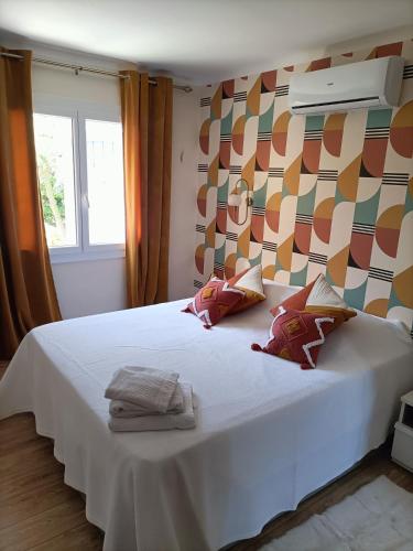 une chambre avec un lit blanc avec des serviettes dessus dans l'établissement Villa Les Vignes, à Flayosc