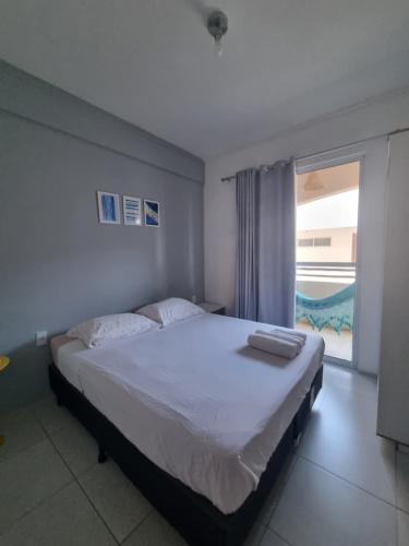 - une chambre avec un lit et une grande fenêtre dans l'établissement Cumbuco Residence #203, à Caucaia