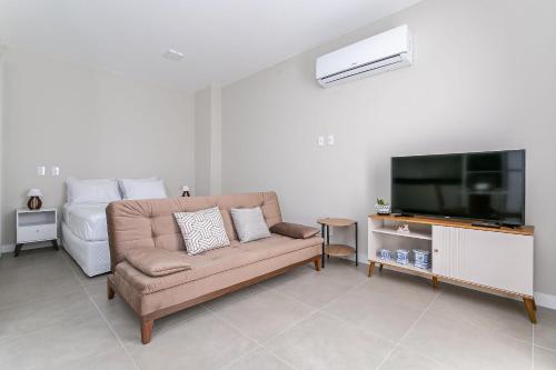 a living room with a couch and a flat screen tv at Wi-Fi 250MB | Sea View | Pool #CA61 in Florianópolis