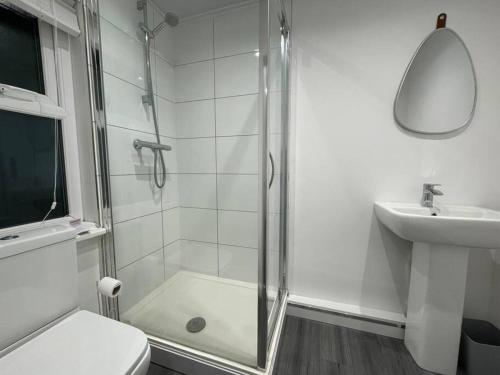 La salle de bains est pourvue d'une douche, de toilettes et d'un lavabo. dans l'établissement The Bank Manager's House - 7Bedrooms - Free Parking - Rest&Recharge near Manchester City Centre, à Manchester