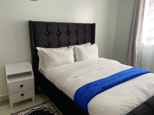Un dormitorio con una cama con una manta azul. en Luxurious furnished home thika road en Nairobi