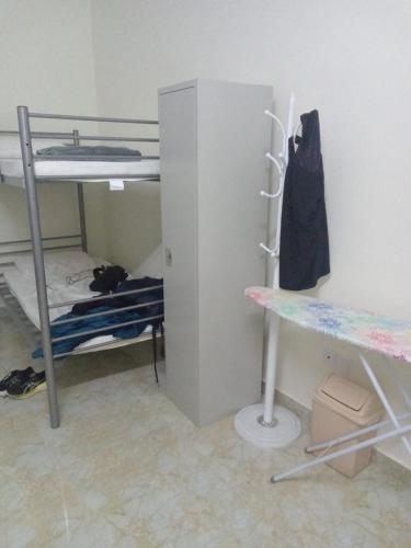 a room with two bunk beds and a desk at Viva Hostel Group Muscat in Doha
