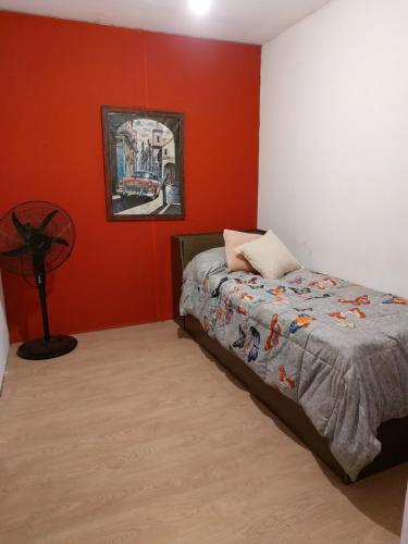 1 dormitorio con cama y pared roja en Cañas y Mar - A 70m del mar, en Cuchilla Alta