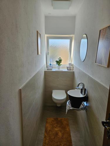 a bathroom with a toilet and a sink and a window at Ferienwohnung Renaissance in Backnang