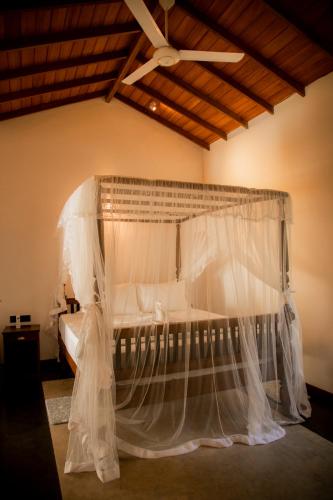 a bedroom with a bed with a mosquito net at Woradi Solitude Bungalow in Talpe