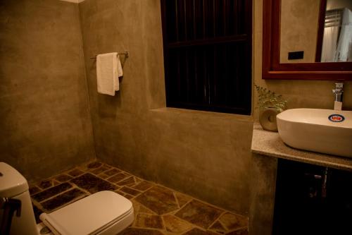 a bathroom with a toilet and a sink at Woradi Solitude Bungalow in Talpe
