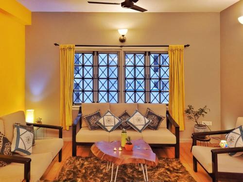 uma sala de estar com um sofá e uma grande janela em Crimson - Sunflower Skyline em Bangalore