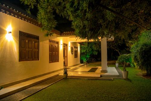 a house with a door and a courtyard at night at Woradi Solitude Bungalow in Talpe
