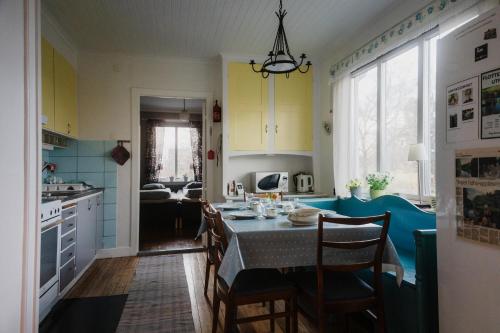 a kitchen with a table and chairs and a kitchen with yellow cabinets at Snickaren Vandrarhem i Grästorp - Egen Lägenhet - Own apartments in Grästorp