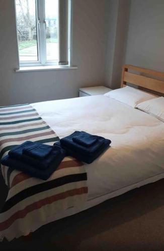 two blue towels sitting on top of a bed at Modern two bed flat in Canada Water close to transport in London