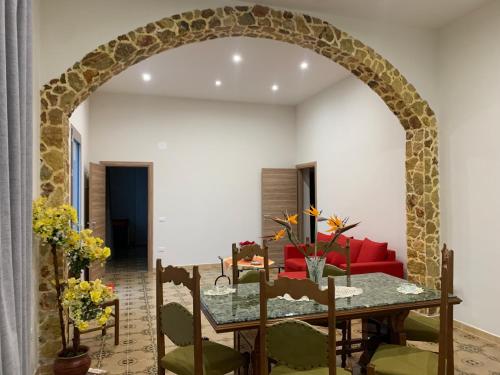an archway in a living room with a table and a red couch at La Mimosa Case Vacanze in Marsala