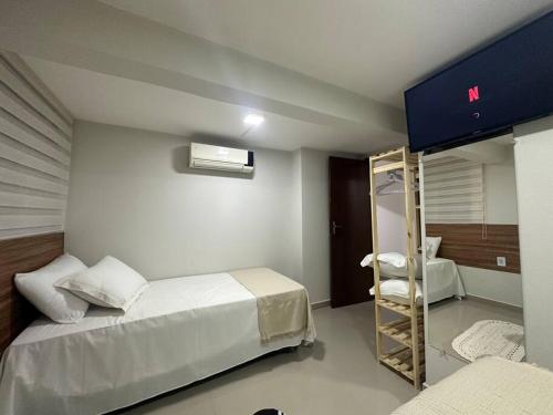 ein Schlafzimmer mit 2 Betten und einer Leiter darin in der Unterkunft Apto 16 lindo e confortável in Montes Claros