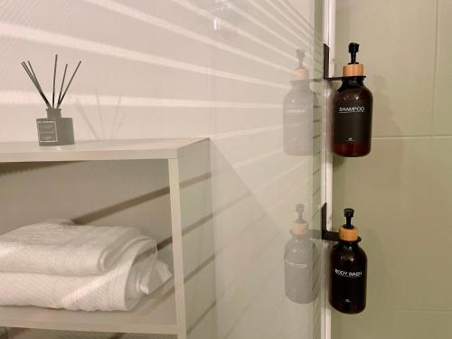 une chambre avec trois bouteilles sur une étagère dans une salle de bains dans l'établissement Le Colorado - Appartement proche Airbus, à Colomiers