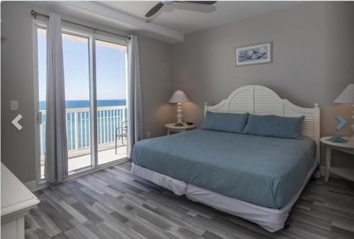 1 dormitorio con 1 cama y balcón con vistas al océano en Silva Sands, en Panama City Beach