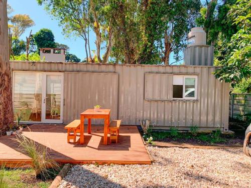 un tavolo e due sedie su una terrazza in legno con un edificio di CABAÑA MOAI a Mar del Plata