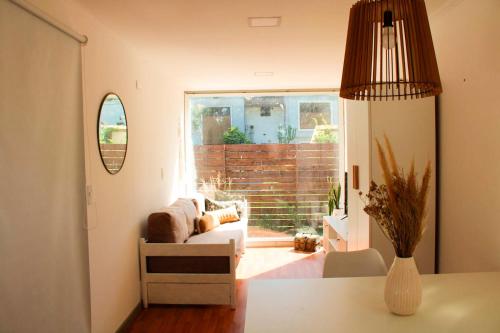 a living room with a couch and a large window at CABAÑA MOAI in Mar del Plata