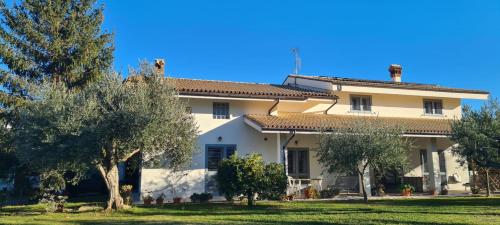 ein großes weißes Haus mit Bäumen davor in der Unterkunft Green Paradise in Sulmona