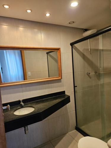 a bathroom with a sink and a glass shower at BEACH FLAT in Salvador