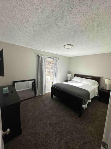 ein Schlafzimmer mit einem großen Bett und einem Fenster in der Unterkunft Wander & Stay Getaway in Logan